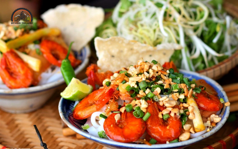 Mì Quảng - A turmeric-infused noodle dish with shrimp, pork, quail eggs, peanuts, and fresh herbs, with very little broth