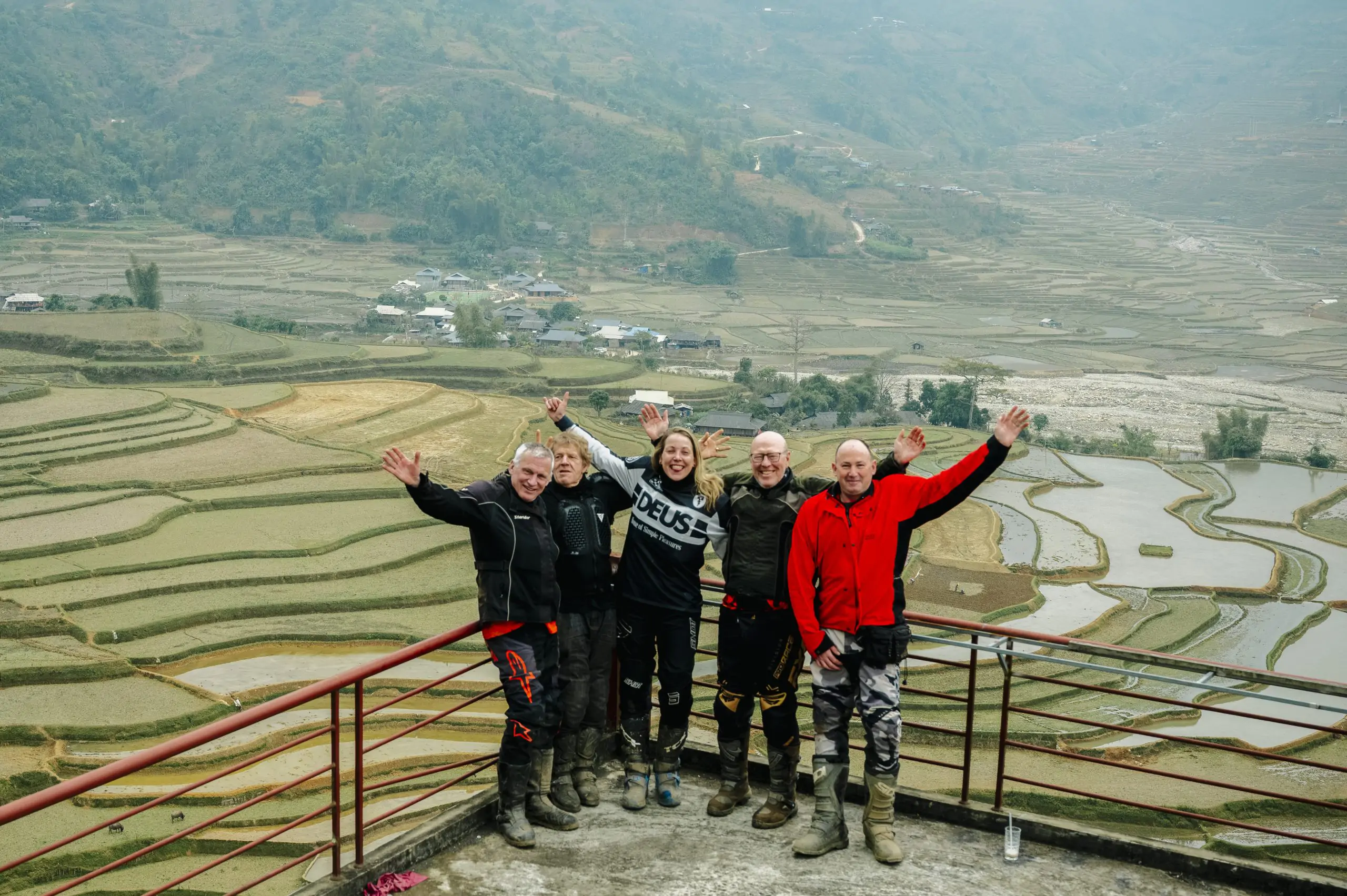 Travelers enjoying a panoramic view of terraced rice fields in Ha Giang, Northern Vietnam.