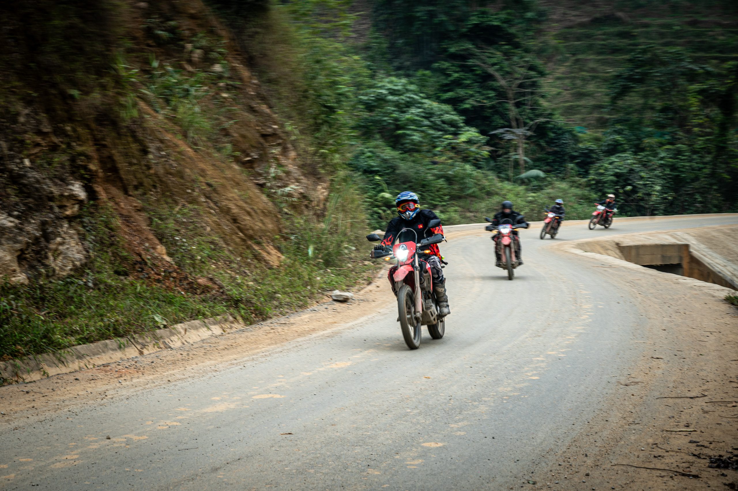 Motorbike riders traveling along a winding mountain road in Northern Vietnam.
