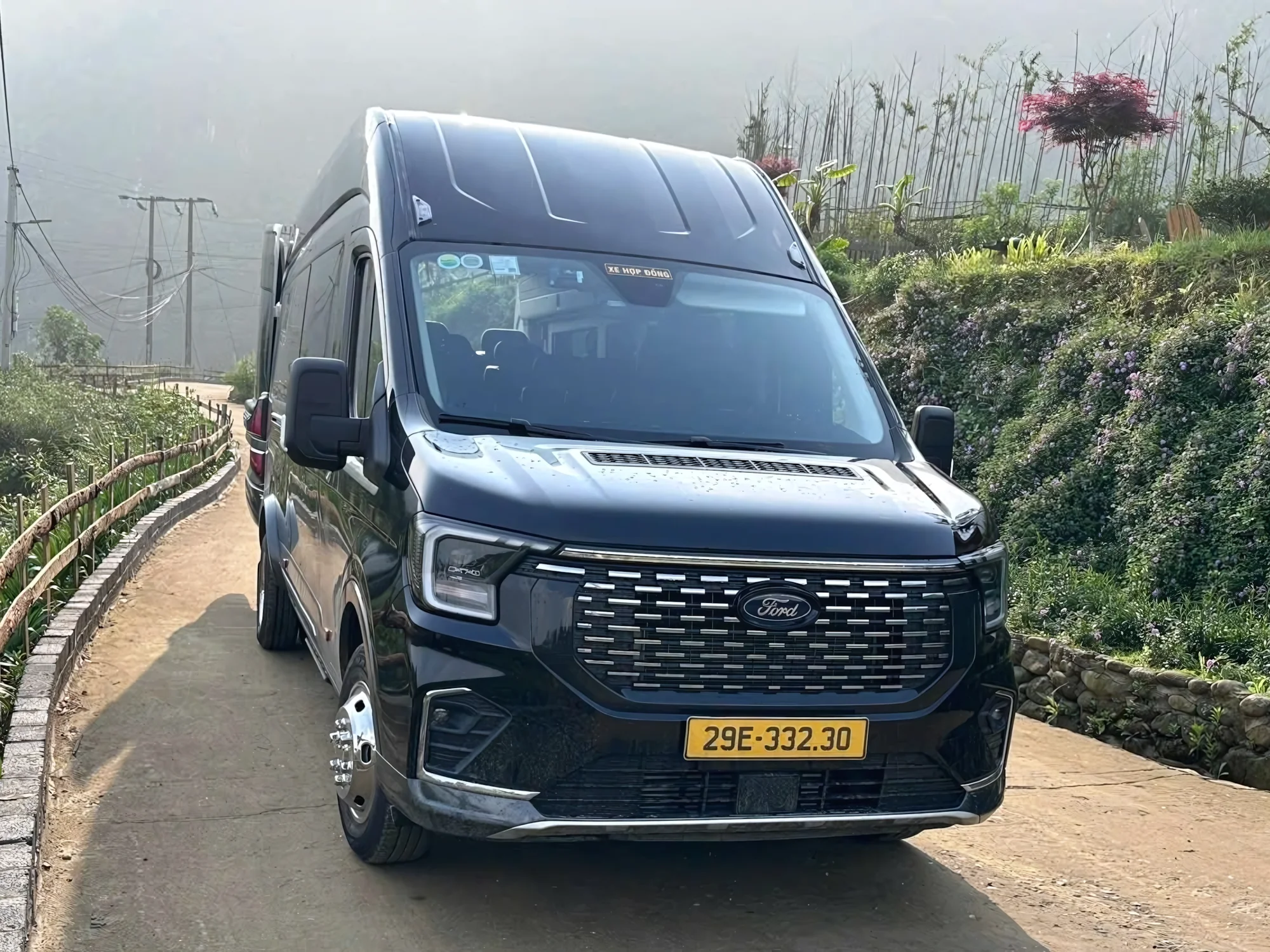 Private limousine van traveling on a scenic mountain road in Northern Vietnam.