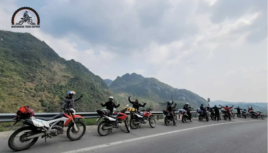 Group of riders on motorbikes along a scenic mountain road in Northern Vietnam.