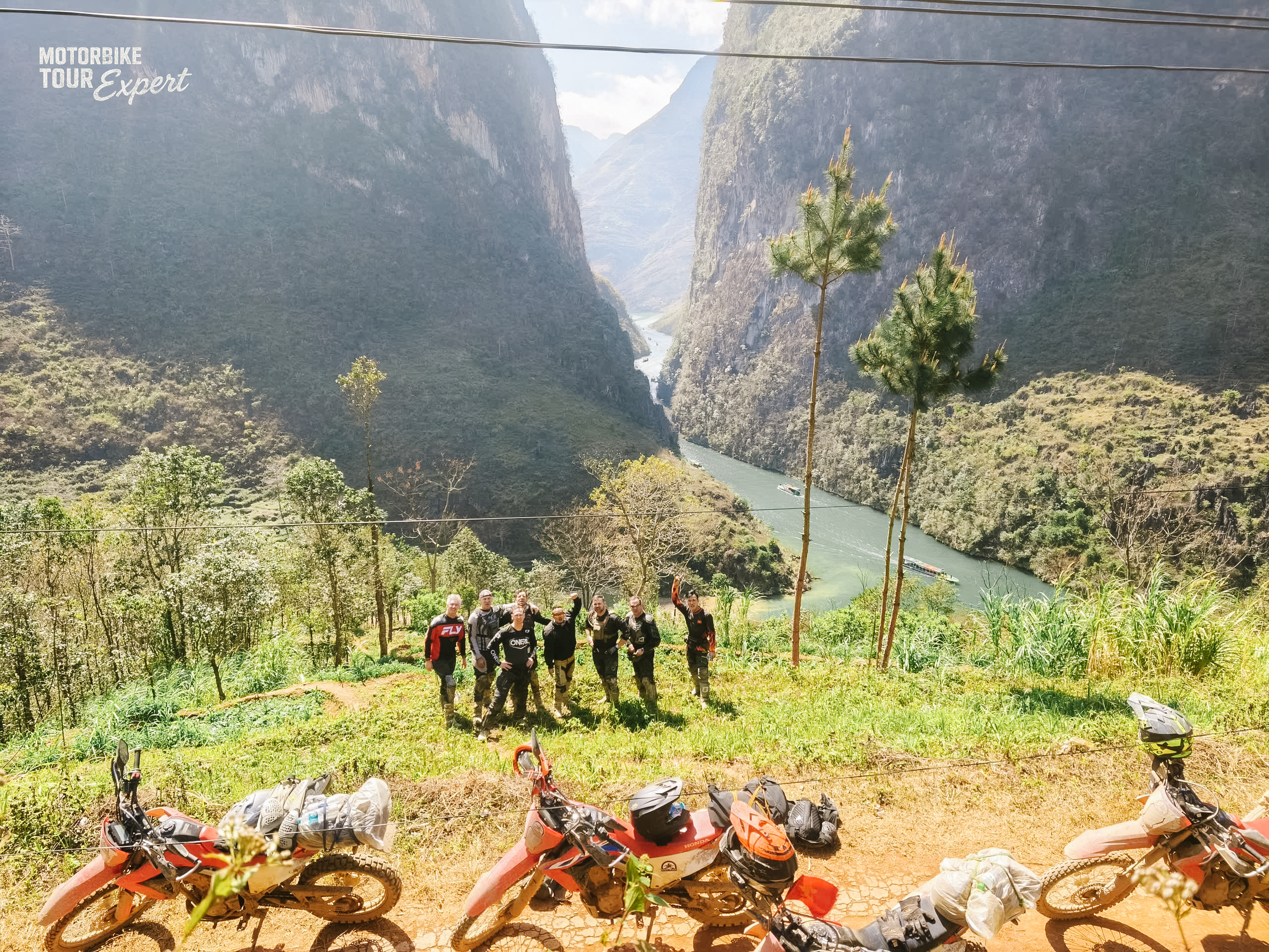 Motorbike riders overlooking a scenic lake and mountain valley in Northern Vietnam.