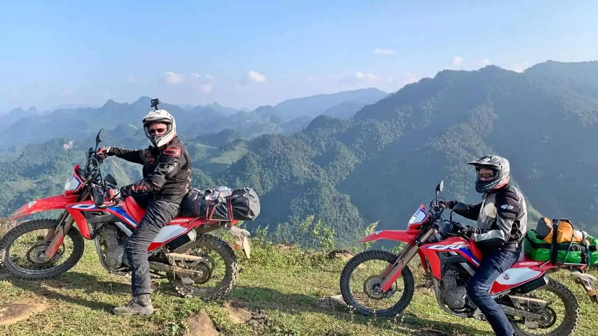 Two motorbike riders enjoying a mountain view along a route in Northern Vietnam.